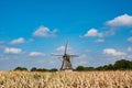 View on grain wind mill in Veldhoven and farmer field with ripe yellow corn ready to harvest Royalty Free Stock Photo