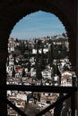 View of the Granada City through an arch window at Alhambra Palace, Spain