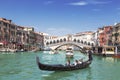 View of the Grand Canal, gondola with tourists and the Rialto Bridge. Venice