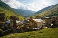 view of grassy field with old weathered rural buildings and hills on background, Ushguli, Royalty Free Stock Photo