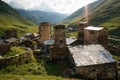 view of grassy field with old weathered rural buildings and hills on background, Ushguli,