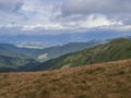 View from grassy hill slopes of hiking trail from Chopok at mountain meadow landscape of ridge Low Tatras mountains Royalty Free Stock Photo