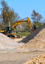 View into a gravel pit with piles of sand and some tire tracks