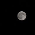 View of the gray full moon in the dark night sky
