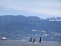 View of Greater Vancouver`s Northshore Mountains with three yachts and ship in the foreground, British Columbia, Canada, 2018