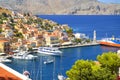 View on Greek sea Symi island harbor port, classical ship yachts, houses on island hills, tourists Aegean Sea bay. Greece islandsV Royalty Free Stock Photo