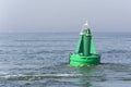 View on a green buoy in the sea, a device to safeguard ships and boats. Royalty Free Stock Photo