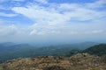 view of green forest and blue sky from the top of the rock