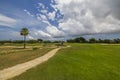 View of green grass golf field on background blue sky with white clouds on Aruba. Royalty Free Stock Photo