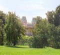 View from a green hill to a fabulous palace in a gap between the trees