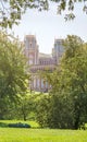 View from a green hill to a fabulous palace in a gap between the trees