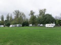 View of the green lawn with white vans next to the path