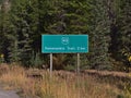 View of green road sign with white lettering beside rural road in Kananaskis Country, Alberta, Canada. Royalty Free Stock Photo