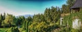 View on green trees forest, blue sky and mountains through a wooden window frame of an old house cottage in southern Poland Royalty Free Stock Photo