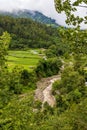 View of green valley with clouds over mountains in Bhutan. Royalty Free Stock Photo