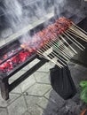 view of the grilling process of street sellers& x27; chicken satay
