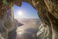 The view from the grotto with icicles, chunks of ice and hummocks to the sun and blye sky. Natural background. Royalty Free Stock Photo