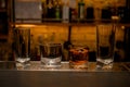 view of a group of empty and one full cocktail glasses on the bar counter.