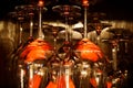 View on group of isolated red yellow shiny glowing wine glasses in cupboard