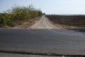 View of the half-asphalt crossroad on the field near the sea