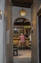 View from hallway of stucco building - bar in Southwestern USA with blurred figures of two men sitting at bar in the distance