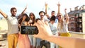 View of hand holding phone and filming group of friends having fun