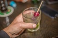 View of hand picking up a glass of refreshing liquor on bar Royalty Free Stock Photo