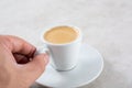 Hand holds small espresso cup