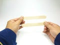 View of hands holding wooden ice cream stick isolated on white background Royalty Free Stock Photo