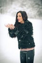 View of happy brunette girl playing with snow in winter landscape. Beautiful young female on winter background. Attractive woman Royalty Free Stock Photo