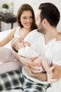 Happy family with newborn baby on the bed in room Royalty Free Stock Photo