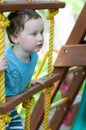 Happy little child boy climbing on the rope ladder outside Royalty Free Stock Photo