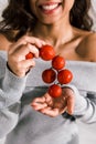 View of happy woman holding red and fresh cherry tomatoes Royalty Free Stock Photo
