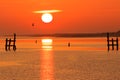 Morning sun with halo shining over bay by golden-orange sky and sea, sunrise scene Royalty Free Stock Photo