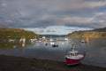View of the harbour in the town of Portree with boats in the bay and a cruiser ship leaving the harbour, in the Island of Skye, Sc Royalty Free Stock Photo
