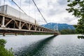 Truck Crossing a Suspemsion Bridge over a River in the Mountains