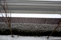 View of the hedge from the upper window of the house. trees and a fence made of planks. everything is snowy even roads and street