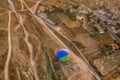 A view from a height of a balloon lying on the ground, being prepared for the flight, and vineyards, fields and houses.