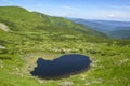 View from the height, to Alpine lake Nesamovyte under hill among a green mountains of Chornohora Ridge, Ukraine Royalty Free Stock Photo