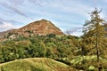 View of Helm Crag across a wooded landscape.