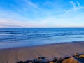 View of Hendaya beach at sunset. With dog walking on the sand and surfers in the sea waiting for the wave Royalty Free Stock Photo