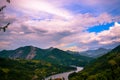 A view from a high place on the beautiful hills, mountains and lake. Sunset and beautiful cloud color in the sky in the background Royalty Free Stock Photo