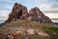 View of the high rocky stones of the Shamanka rock against the sky with clouds on Lake Baikal. Royalty Free Stock Photo