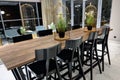 View of a high table with chairs, lamps hang above the table, interior background, out of focus