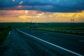 View of the highway, road, with car traffic in the evening against the background of a stormy sky with an orange sunset Royalty Free Stock Photo