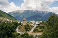 view of highway road and houses of small village with hills on background, Ushguli,