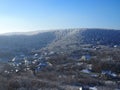 View from the hill to winter landscape with farmstead and forest, scenic winter view to valley, tranquil winter countryside,