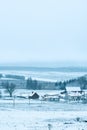 View from the hill to winter landscape with farmstead and forest, scenic winter view to valley