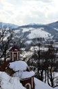 View on hills surrounding city of Banska Stiavnica from baroque middle church of calvary during cloudy snowy winter season