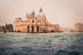 View of historical buildings surrounded by water in the morning mist in the city of Venice